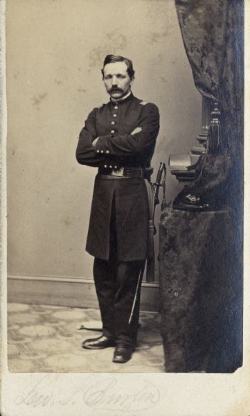 Full-length carte-de-visite portrait of Captain Lewis S. Burton, Company B, 30th Wisconsin Infantry, standing in full uniform with his sword on his left side.