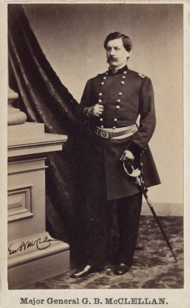 Full-length carte-de-visite portrait of Major General George B. McClellan holding his sword in his left hand. At Major General in the Regular Army. After the First Manassas be was promoted to Commander of the Army of the Potomac, and by November 1861 he was appointed General-in-Chief of the Armies of the United States, where he would serve until November 1862 when the War Department ordered him home to await orders.