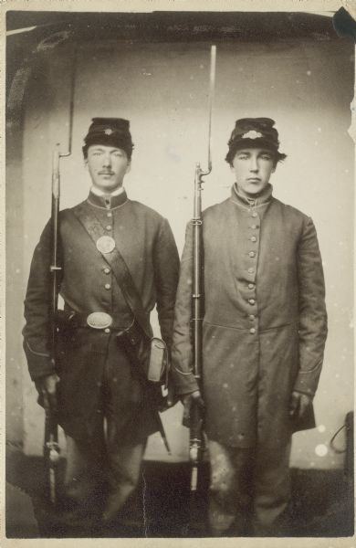 Three-quarter length portrait of Herman and Lewis Gudmundsen from Dunkirk, Wisconsin. They enlisted into Company A, 23rd Wisconsin Infantry, on August 15, 1862. Herman became a prisoner on October 13, 1863 and was mustered out of service on June 21, 1865. Lewis died from disease while in New Orleans on October 13, 1863.