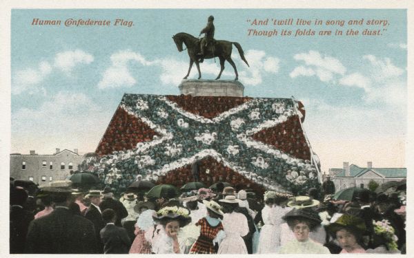 Colored postcard view of crowd in front of the stand. Caption reads: "Human Confederate Flag." Text at top right reads: "And 'twill live in song and story. Though its folds are in the dust." One of the most pleasing as well as spectacular features of the great reunion of Confederate veterans, was the arrangement and costuming of 600 school children occupying a stand within the Lee Monument enclosure and aroused the greatest enthusiasm by their singing of "Dixie" and other Southern airs. The event was held in Richmond in May-June, 1907, relating to the unveiling of the Jeb Stuart and Jefferson Davis Monuments.