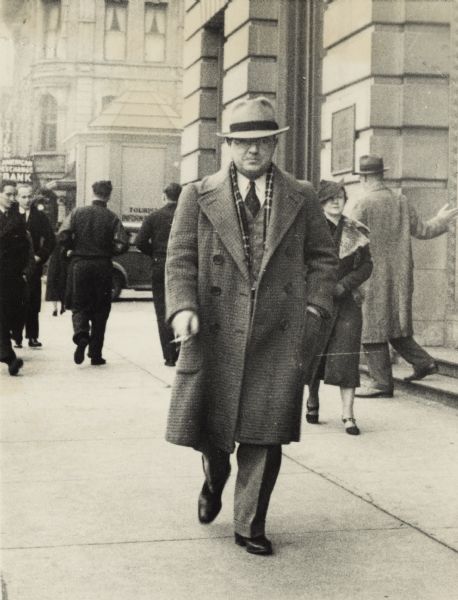 Leon Lamoreux on South Pinckney Street Leon Lamoreux walking down the sidewalk on South Pinckney Street, Capitol Square. The building on the right is the First National Bank (now the "glass" bank). There is an information booth and American Exchange Bank in the background. Leon, and his wife Beatrice, later taught typing and telegraphy to Naval students at the U.S. Naval Training School (Radio) in Madison.