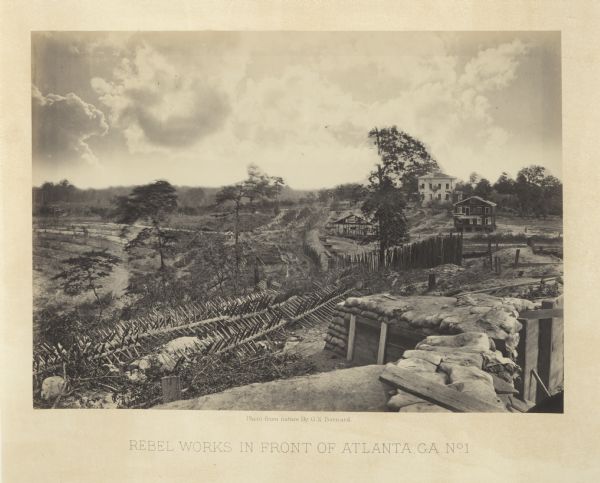 View looking out from one of the Confederate defenses around the outside of the city. Wooden palisades surround the earthworks. Houses and other buildings in the background are heavily damaged.<br>Plate 39</br>