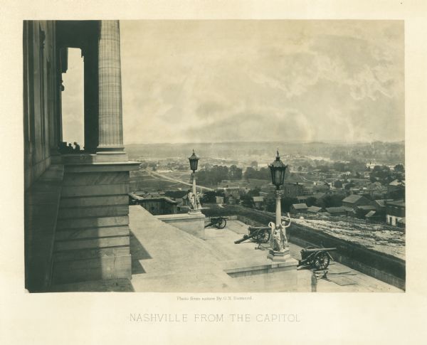 View down capitol building steps, where cannons sit on a landing, and statues decorate two lampposts. The city spreads out far below.<br>Plate 03</br>