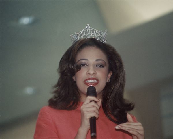 Miss America 2003, Erika Harold, at Valley View Mall, wearing a crown and holding a microphone.