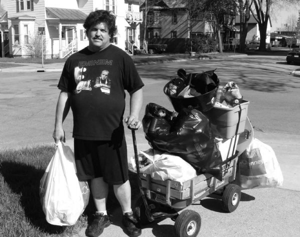 James, a recycling man, poses with his wagon of recyclables.