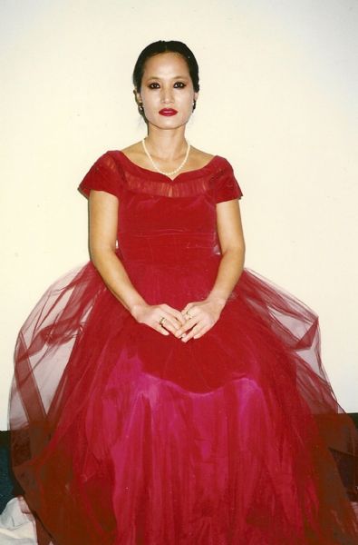 Suk-Hee Sim Marcou Hall, the former wife of the photographer, poses for a portrait in a red dress.