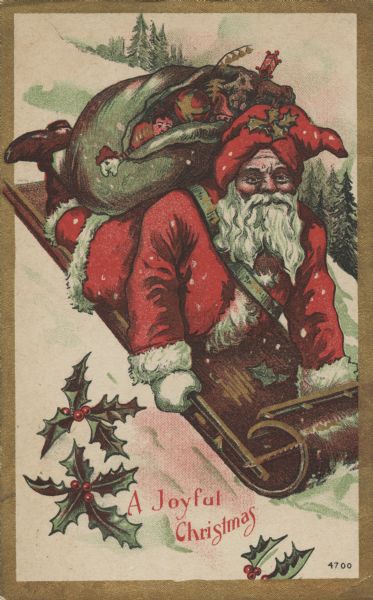 Holiday postcard with Santa Claus sledding down a snow-covered hill on a toboggan with a sack of toys on his back. He is wearing his traditional red hat with holly on it, and a white fur-trimmed red suit. Trees are in the background, and holly is in the foreground. The postcard has a metallic gold border. The text: "A Joyful Christmas" is at the bottom. Chromolithograph. Embossed throughout with a fine pattern.