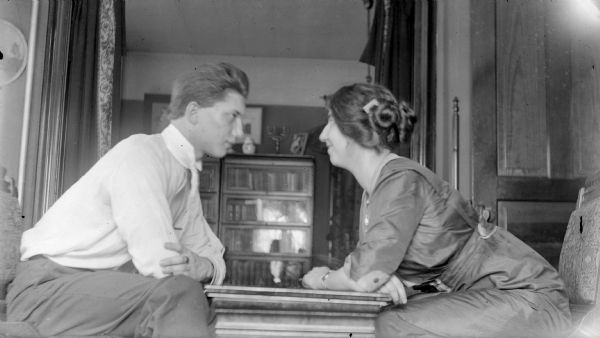 Ben Goldenberger and his sister Olivia face each other over a small table. There is a menorah on the bookcase in the background. Ben would later change his last name to Bergor and become a professional magician. Olivia, performing as Olivia Monona, was a successful opera singer, performing with the Chicago Opera, and later, the Metropolitan Opera.