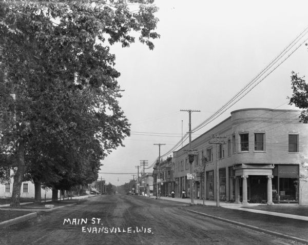 View down Main Street. A group of women are looking in store windows on the right.