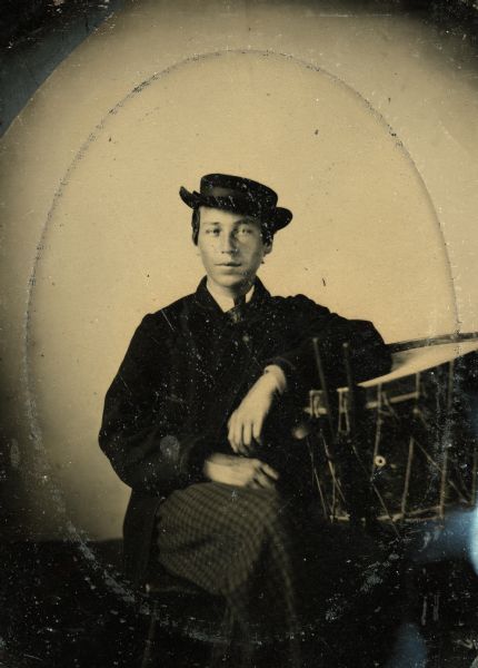 Tintype portrait of Josh Sullivan of Oshkosh, Wisconsin, member of the 3rd Wisconsin Infantry band. He is seated leaning on a drum.