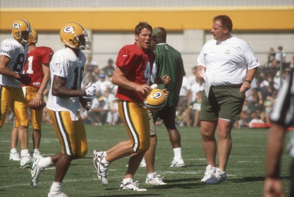 Brett Favre with coaches and other players on the Packer practice field during a scrimmage(?). This photograph was taken for the Wisconsin Division of Tourism.