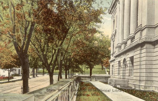 Colorized postcard of the State Street entrance of the State Historical Library, now the headquarters building of the Wisconsin Historical Society. Bascom Hill is in the background. The text below reads "State Street Entrance to Historical Library, Madison, Wis."