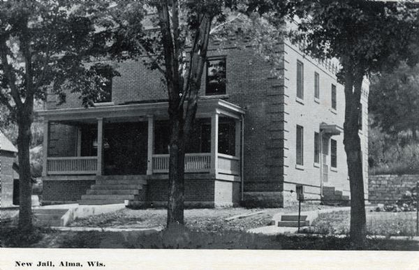 Photographic postcardview from across a street of the exterior of the new two-story brick jail. Caption reads: "New Jail, Alma, Wis."