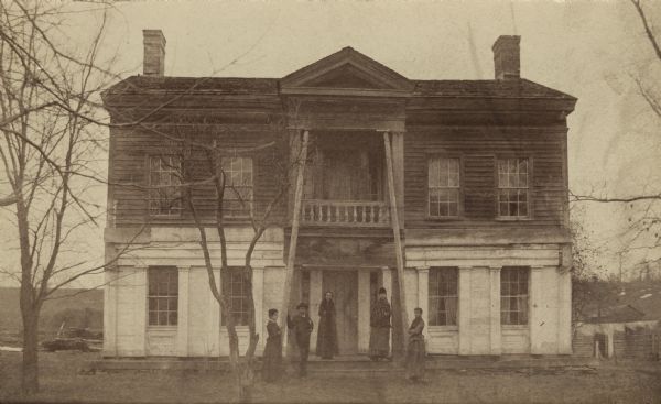 The house built by Charles A. Grignon between 1837 and 1839 for Mary Meade, his Pennsylvania bride. Mrs. Grignon and her family are standing in front of the house. The house is already quite deteriorated as the second story balcony is gone and the pediment is supported from below. The house was restored by Outagamie County in 1940 and it is now a museum.