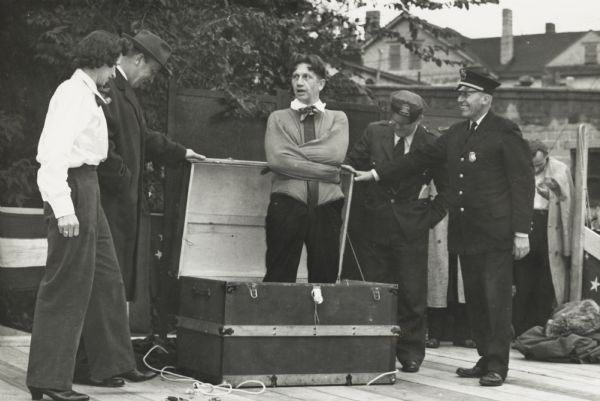 Madison magician Ben Bergor, standing in the trunk, and his wife, Alvina, standing nearby, getting ready to perform an amazing escape act. The act had Bergor, straightjacketed and inside a locked trunk. He escapes and is replaced by his wife.