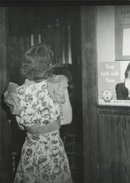 A woman turns her back on an agent as they enter the establishment where she worked at the beginning of a raid on many Hurley area bars. The arrest warrants were for gambling and prostitution.