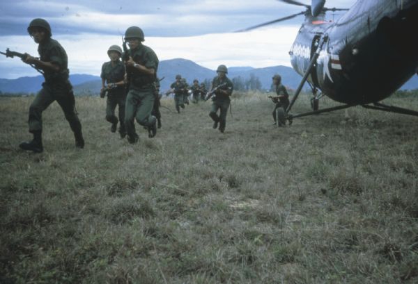 Vietnamese Assault on Village Vietnamese soldiers exiting from U.S. Army helicopter and running across a field with guns drawn to assault a village suspected of harboring Viet Cong in the vicinity of Soc Tranh, Vietnam.