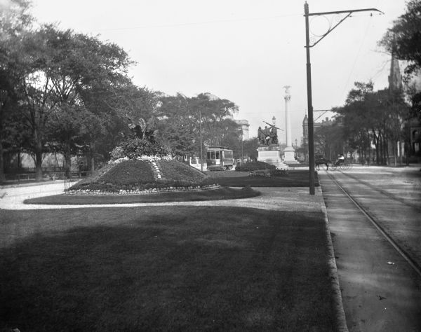 View down Grand Avenue. Near a streetcar is the city's Civil War memorial, erected in 1898 by John Conway.