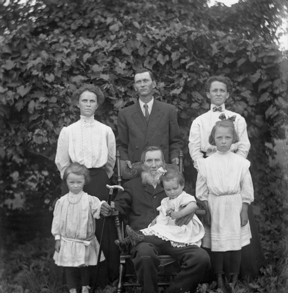 William Wendorf Family Outdoor portrait of the William Wendorf family. William Wendorf is sitting in a rocking chair holding a cane, while Mabel Kyzowski is sitting on his lap. On either side of him are standing Ruth and Alice Kressin. Behind them standing are Martha Wendorf Kressin, Ed Wendorf, and Minnie Wendorf Kyzowski.
