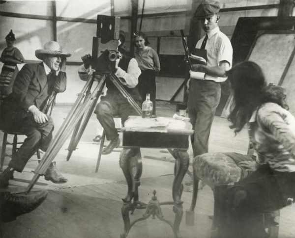 D.W. Griffith, wearing a straw hat, directs Miriam Cooper in "Intolerance." Cameraman Billy Bitzer is obscured by the Pathé camera he is cranking. Behind him actress Dorothy Gish watches the scene. On the right, Bitzer's assistant Karl Brown is keeping script.