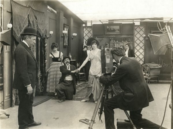 Mack Sennett (in suit and derby) directs Chester Conklin (on his knees) as Ernest B. Schoedsack cranks a Moy & Bastie silent film camera for an unidentified Keystone Comedy.