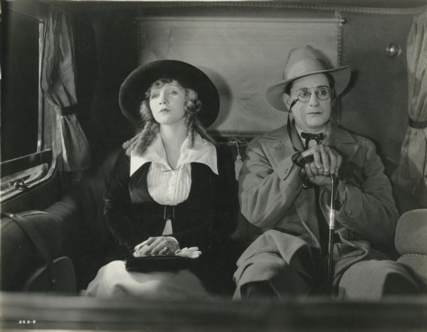 Yvonne Halbert (played by Mary Miles Minter) and Lawrence Bartlett (Alan Forrest) make pains to ignore each other as they sit side-by-side in the back of an automobile in a scene still from "Yvonne from Paris." Bartlett wears pince-nez.