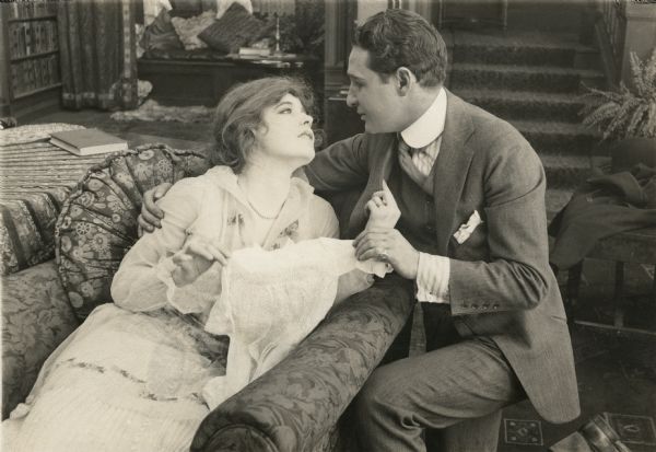 Ethel Clayton, stretched out upon a chaise lounge, is being made love to by Joseph Kaufman in a love scene from "A Woman Went Forth" (Lubin 1915).