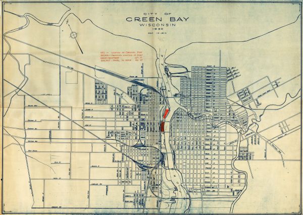 This map shows a plat of the town, local streets, railroads, creeks, part of Fox River, and part of the bay of Green Bay. The location of the original fort is in red and the proposed location of fort in brown.