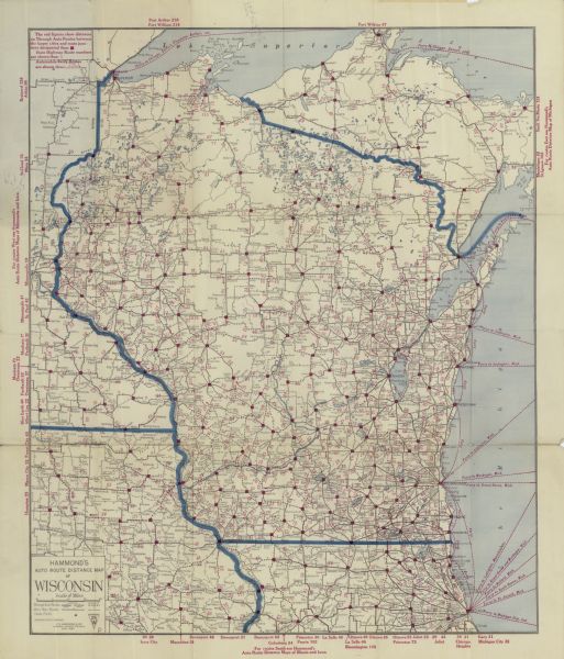 This map shows the entire state plus portions of Illinois, Iowa, Minnesota, and Michigan outlined in blue. The map shows roads, state parks (black triangles), cities, rivers, and lakes. Ferry lines on Lake Michigan and Lake Superior are labeled in red. The upper left corner includes an explanation of the red boxes shown on the map: "The red figures show distances on Through Auto Routes between the larger cities and route junctions designated thus: [red boxes] State Highway Route numbers are shown thus: 1". In the margins are cities with route distances labeled in red. 