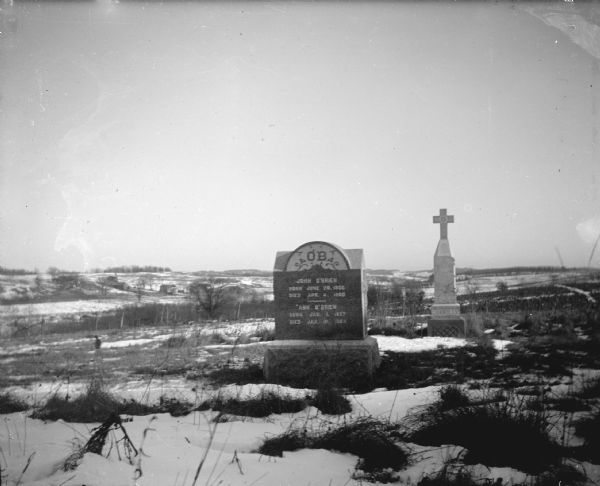 Tombstone of John and Ann O'Brien View towards tombstones in a snow-covered cemetery with tall grass. Identified as the memorial of Ann and John O'Brien and Connolly at the Roaring Creek Cemetery.