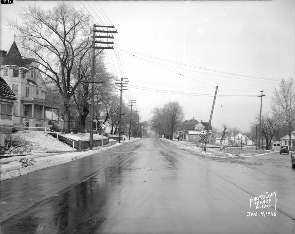 Winnebago Street from the Yahara River Bridge, scene of accident, near railroad crossing. There is a Victorian house at left, 1628 Winnebago Street, with a small house far right at 301 Clemons Avenue.
