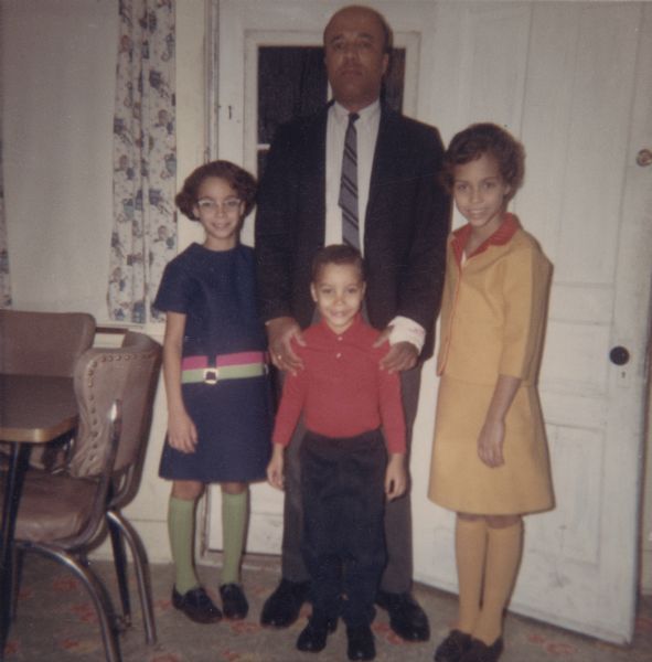 Lewis Arms and Children Lewis Arms posing with his daughters Mamie (left) and Rita (right), and his son Paul. Arms is wearing a suit and necktie and the girls are wearing dresses.