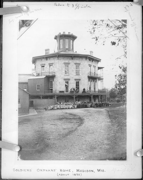 Group of people posing outside of Soldiers' Orphans Home, located on Spaight Street between Paterson and Brearly Streets. The building was originally constructed by Governor L.J. Farwell, about 1853, as a private residence. It was opened on January 1st, 1866 as the orphan asylum; Mrs. Cordelia Harvey, widow of Governor L.P. Harvey, was in charge. According to <i>The Jefferson Banner</i>, 23 January 1867, this photograph was sold for $3.75, with "35% of the proceeds to go for the benefit of the home . . . Every person should purchase a copy and thereby assist the soldiers' orphans of Wisconsin in obtaining an education."