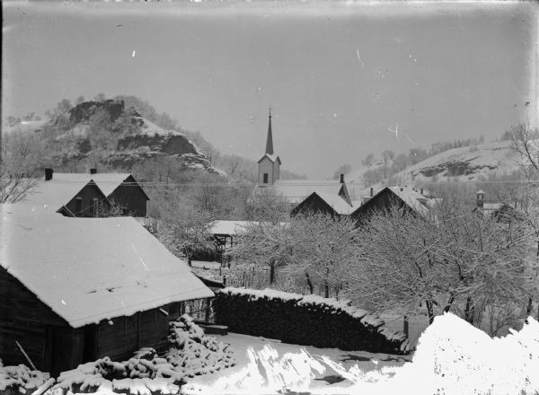 Winter scene overlooking town, showing Baptist church in background.