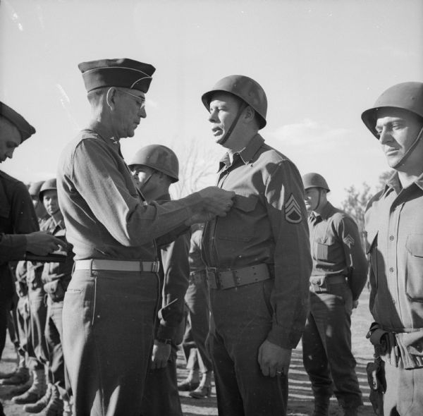 Major General William Hanson Gill awards the Distinguished Service Cross to Staff Sergeant Milan Miljatovich of Milwaukee, Wisconsin, at Camp Cable, near Brisbane, Australia.
