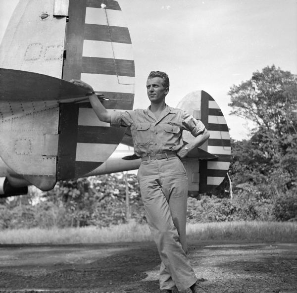 Major Arthur L. Post of Milwaukee, Wisconsin, was shot down on June 20th, 1943 and rescued on September 28th, 1943 after 101 days in the jungle. Here he is pictured leaning on the tail assembly of a plane similar to his unarmed photo plane, "Limping Lizzie," that was shot down. The airfield where this image was taken was located near Port Moresby, New Guinea (present day Papua New Guinea). Robert Doyle was not allowed to publish Post's story at that time. It was finally published in January, 1947, by the <i>Milwaukee Journal</i>. Major Post intended to write his own story, but was killed in a test airplane on August 25th, 1944, before he had the chance.