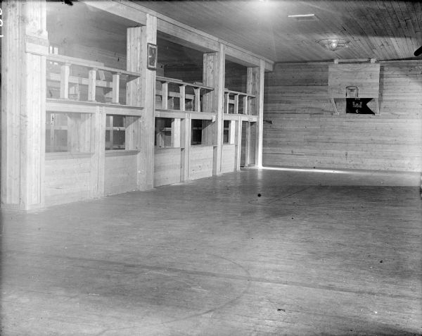 The recreation hall of Company C, 310th United States Army Engineer Corps. There is a basketball hoop with a backboard. The portrait on the wall appears to be President Woodrow Wilson. The sign on the first post reads, "Robbers one Step."