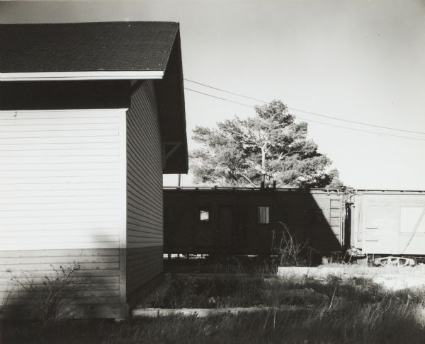 Railroad freight station and siding, with railroad cars.