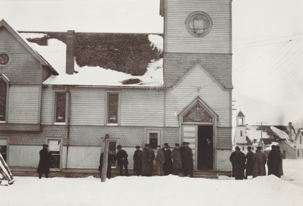 Men gathered around the entrance to a church where a meeting of the State Agricultural Association has been held.