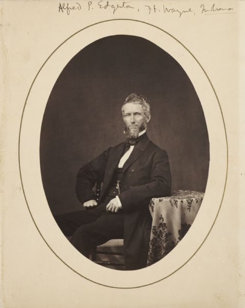 Formal portrait of Alfred P. Edgerton seated at a small table.