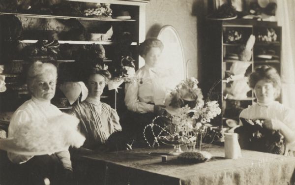 Mrs. Rossing's millinery shop. Left to right: Mrs. Rossing, Viola Rossing, Anna Davis and the trimmer.