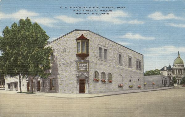 O.A. Schroeder & Son, Funeral Home Illustrated postcard of a funeral home on the corner of King Street and East Wilson Street. The Wisconsin State Capitol is at the end of King Street. Caption reads: "O.A. Schroeder & Son, Funeral Home, King Street at Wilson, Madison, Wisconsin."
