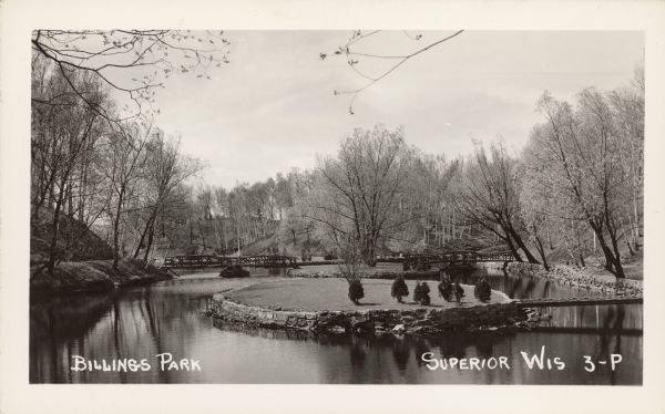 Billings Park Text on front reads: "Billings Park, Superior, Wis." A city park on the St. Louis River, a freshwater estuary. Small islands with several bridges are surrounded by hills and trees. The islands and some shorelines have decorative stone walls.