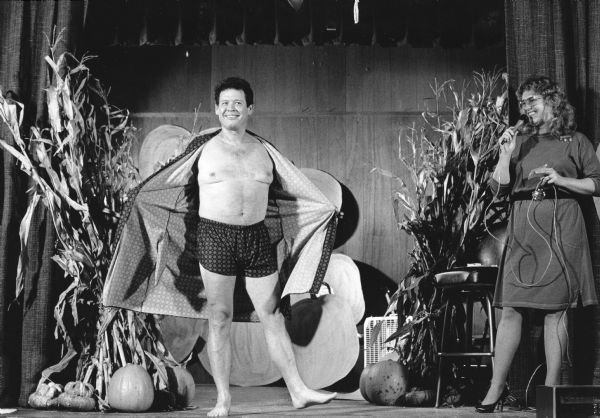 Jim Wiseman, husband of Louise Wiseman, drew some laughs when he appeared on stage at the Lioness Club Fashion Show. Wiseman wore a checked robe and boxers. Stage decorated with pumpkins and cornstalks.
