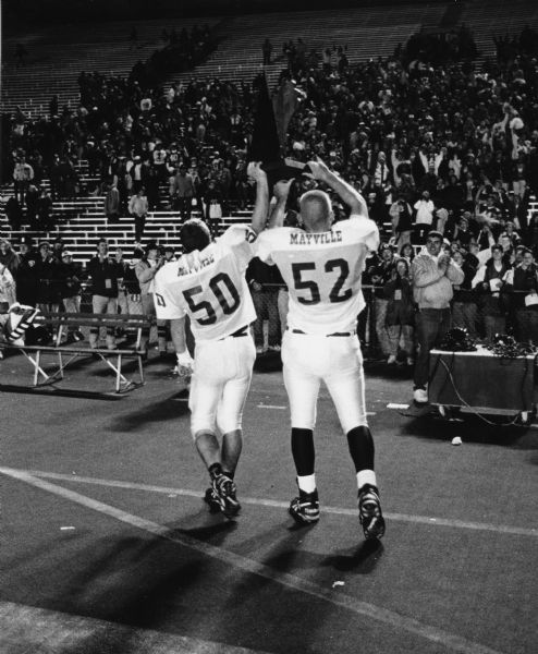 Dave Vanden Boom, #50 and Mike Lange, #52, proudly show the WIAA State Championship trophy for Division 4 against Baldwin-Woodville. Championship game played at Camp Randall Stadium.