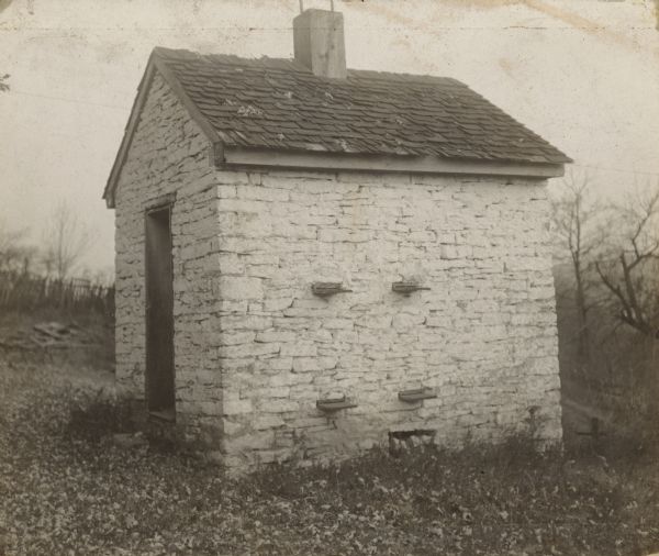 Stone "bee house". Writing on back: "An old stone bee house in Sarchem, Indiana. The hives were arranged on shelves on the inside, and the bees passed through small entrances shown in the pictures. This old house figures in Eggleston's "The Hoosier School Boy."