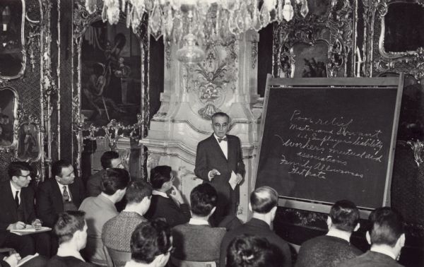Arthur Altmeyer standing at a blackboard speaking at the Salzburg seminar in American studies.<p>Arthur J. Altmeyer (1891–1972) was the United States Commissioner for Social Security from 1946 to 1953, and chairman of the Social Security Board from 1937 to 1946. He was a key figure in the design and implementation of the U.S. Social Security system.