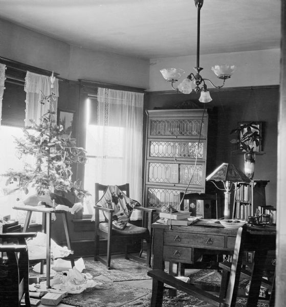 Christmas decorations in an office at Dr. Joseph Smith's house. Wrapping paper from opened gifts lie beneath the decorated Christmas tree.