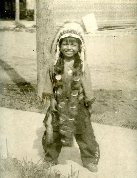 Portrait of Josh Sanford in Native American dress as a child. Sanford served in the Army Air Corps during WWII and is credited with being the only Native American pilot to serve in China. Sanford eventually reached the rank of Captain, won the Fly Cross Award, and took part in at least 74 combat missions. Sanford's mother was a member of the Winnebago Tribe while Sanford's father was a member of the Seneca Tribe.