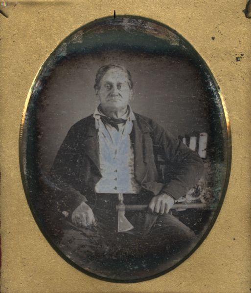 Sixth plate daguerreotype studio portrait of Augustin Grignon. He is seated, holding a tomahawk. The tomahawk, which could also be used as a pipe, was made from a gun barrel by Joseph Jourdain, the government blacksmith in Green Bay. Grignon was a fur trader and settler in Green Bay.